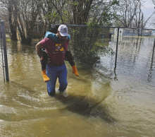 Sheriff Wydette Williams assisted a resident at the corner of Ransdell and Fischer Street from her flooded home. COURTESY PHOTO