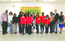 Receiving associate's degrees after having just graduated high school are (in red sweaters, from left) Shamarion Hadmon, Da'Niyah Newell, Ja'Nya Powell, Kaleia Scott, and Laila Lucas. They were flanked in celebration by school officials.