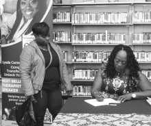 Lynda Carmouche signs her book during an event at the library last week. DEBRA HOPKINS