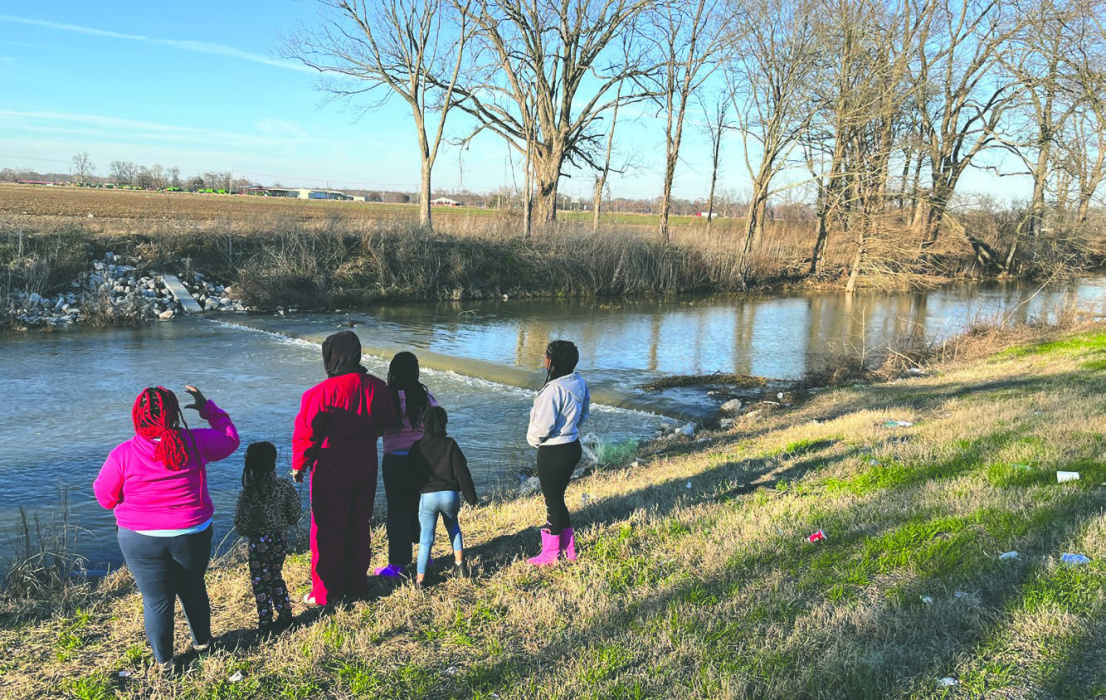 A family gathers to observe overflow from Lake Providence at the Tensas bayou weir. Recent heavy rains have brought lake levels up to heights not seen for a few years, after droughts and a previously-broken weir structure.