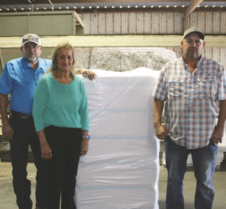 Celebrating the first bale of cotton are (from left) Charles Vining III, Bobbie Vining, and Mark Kirkland. DEBRA HOPKINS