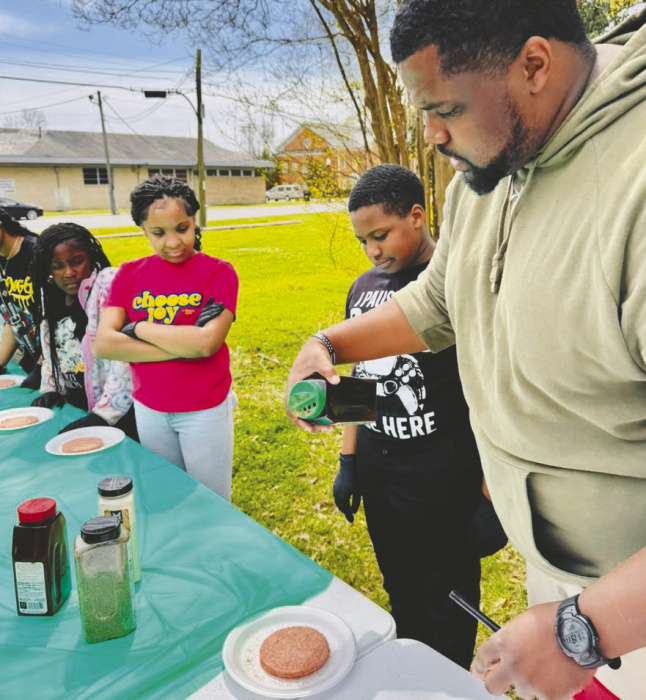 Greg Campbell (right) leads 4-Hers in grilling techniques
