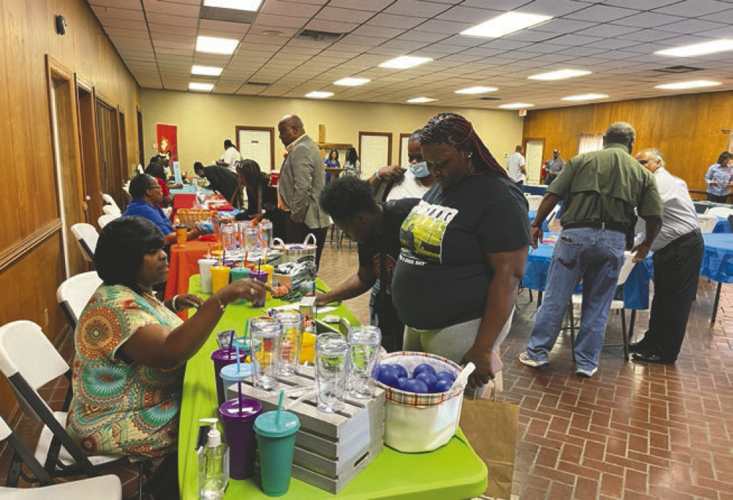 At left, summit attendees visited information tables provided by organizations that support families in East Carroll. At right, some of the organizers of the summit are recognized (from left) Rene Williams, parish clerk of court, Wydette Williams, sheriff, Judge Laurie Brister, Orlando Davis, Office of Juvenile Justice, Judge Angela Claxton, Tommy Morant, East Carroll Parish schools, and Cedric Morales, 6th District Judicial Court FINS office.